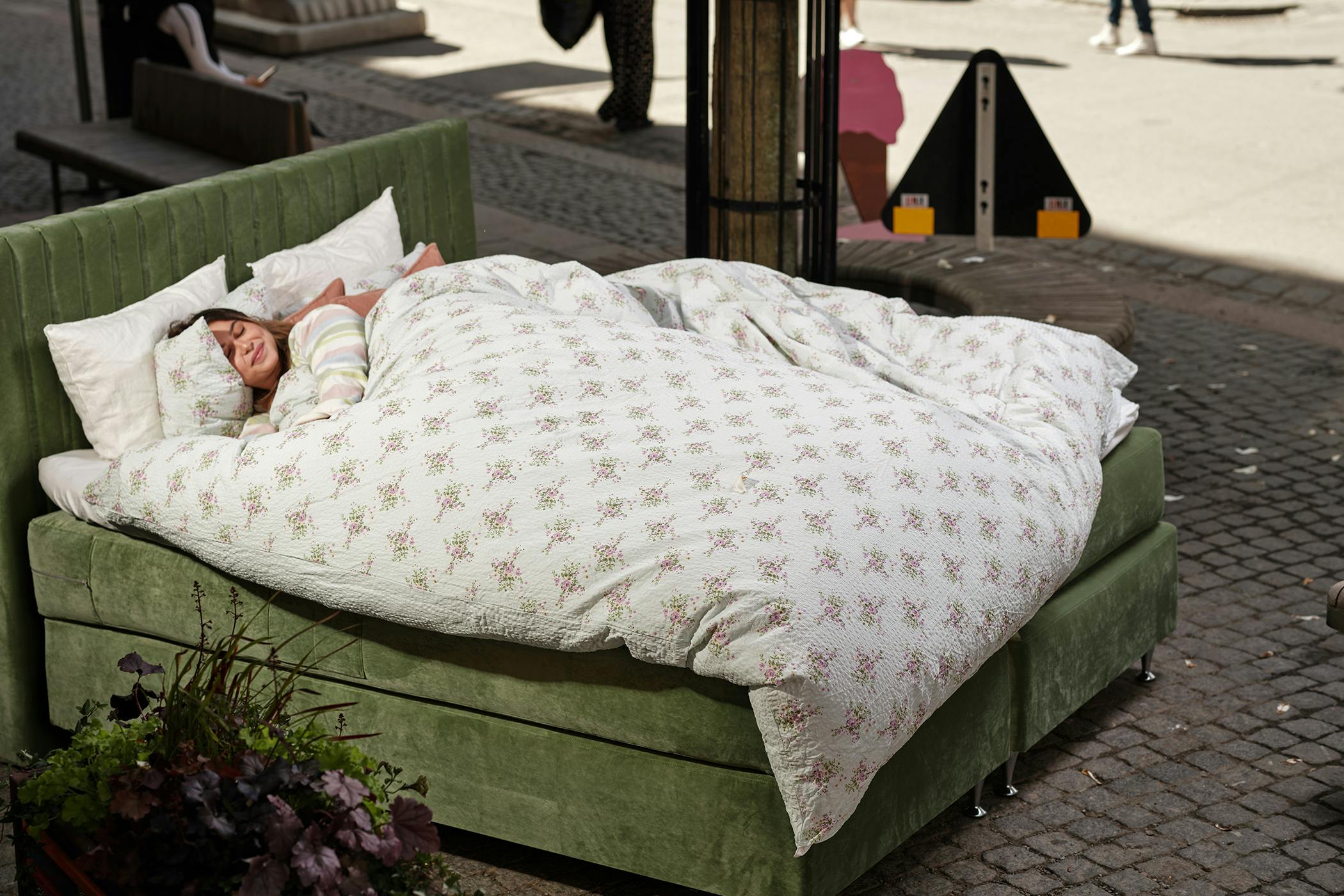 180cm bred dubbelsäng med grön, sammetsklädd stomme och med ribbad, hög sänggavel. 